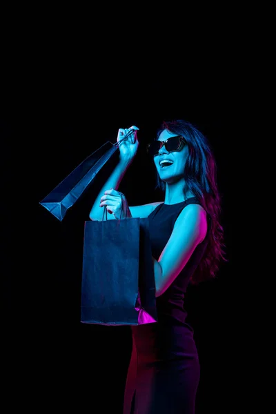 Porträtt av ung kvinna i neonljus på mörk bakgrund. Mänskliga känslor, svart fredag, cyber måndag, inköp, försäljning, ekonomi koncept. — Stockfoto