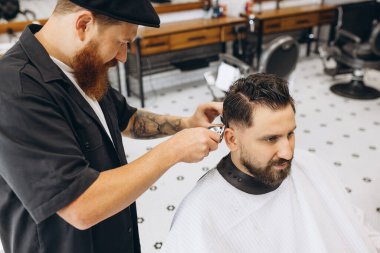 Profesyonel berber, saç kesme makinesi müşteriye saç kesimi, berber dükkanındaki genç adam. Güzellik, bencillik, tarz, moda ve erkek kozmetik konsepti.