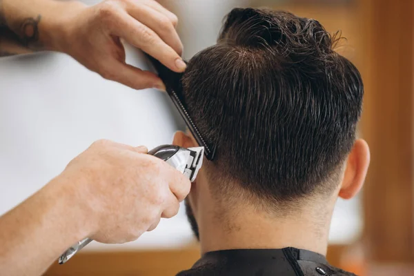 Primer plano peluquero profesional corta el pelo, barba de hombre en la barbería. Belleza, cuidado personal, estilo, moda, salud y cosméticos masculinos concepto. — Foto de Stock