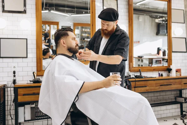 Zwei gutaussehende Männer beim Friseur. Stilvolle rotbärtige Friseurin und Kundin während des Haarschnittprozesses. Schönheits-, Gesundheits- und Kosmetikkonzept für Männer. — Stockfoto