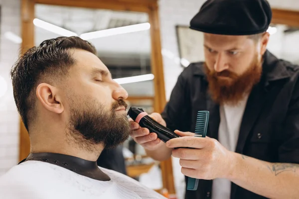 Peluquero profesional, corte de cortadora, barba de afeitar de cliente regular en la barbería. Belleza, autocuidado, estilo, moda y concepto de cosmética masculina. — Foto de Stock