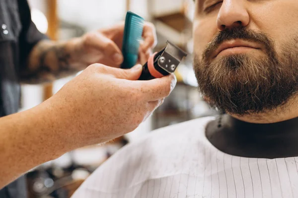Professional barber, clipper cutting, shaving beard of regular customer at barbershop. Beauty, selfcare, style, fashion and male cosmetics concept. — Stock Photo, Image