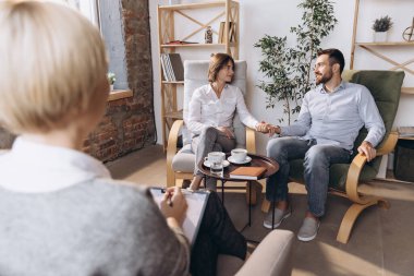 Psikolog randevusunda. Evli çift, genç adam ve kadın danışman ile buluşuyor, aile sorununu çözmek için doktor.