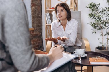 Psikologla görüşmede iki genç kadın, hasta ve doktor psikolojik sorunları tartışıyor..