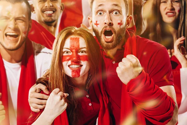 Zbliżenie młody emocjonujący mężczyzna i dziewczyna, kibice piłki nożnej z Anglii dopingują swoją drużynę białymi czerwonymi szalikami na stadionie. — Zdjęcie stockowe