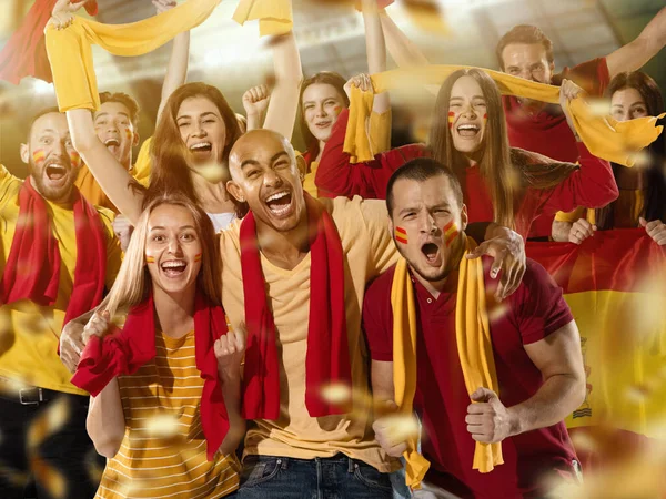 Fútbol español, aficionados al fútbol animando a su equipo con bufandas rojas amarillas en el estadio. Concepto de deporte, emociones, evento en equipo, competencia. — Foto de Stock