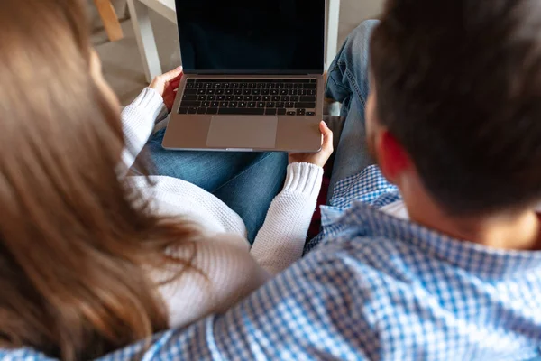 Jovem e mulher de close-up, casal passando tempo juntos em casa, dentro de casa. Casal de meia idade usando gadgets. Visão traseira — Fotografia de Stock