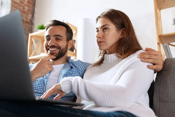 Primer plano joven hombre y mujer, pareja pasar tiempo juntos en casa, en el interior. Pareja de mediana edad usando artilugios. Concepto de familia, relación — Foto de Stock