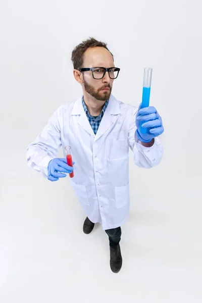 Vue en angle élevé du jeune chimiste, le médecin effectue des recherches chimiques isolées sur fond blanc. Concept de pharmacologie. — Photo