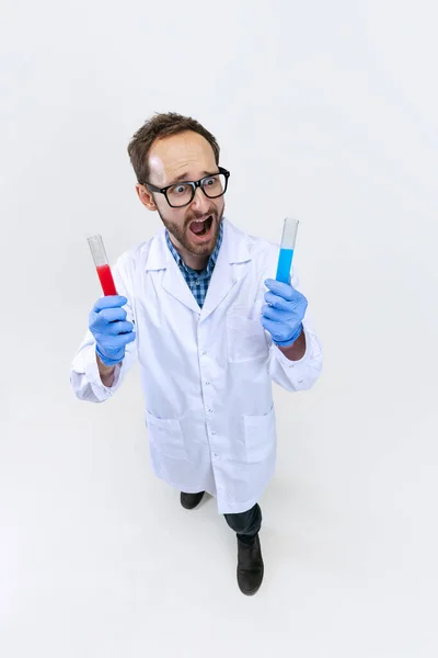 Visão de alto ângulo do jovem químico, o médico realiza pesquisas químicas isoladas em fundo branco. Conceito de farmacologia. — Fotografia de Stock