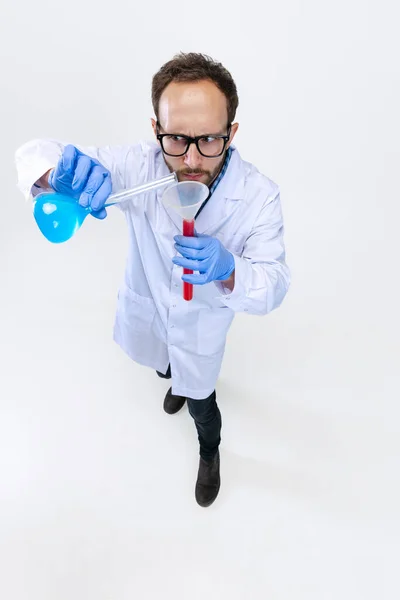 Nagy látószögű kilátás a fiatal vegyész, orvos végez kémiai kutatás elszigetelt fehér háttér. A farmakológia fogalma. — Stock Fotó