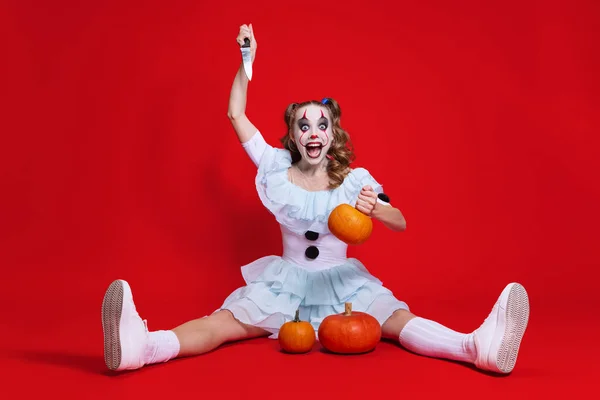 Мистическая блондинка в Хэллоуин макияж смотреть в камеру со страшным выражением лица изолированы на красном фоне — стоковое фото