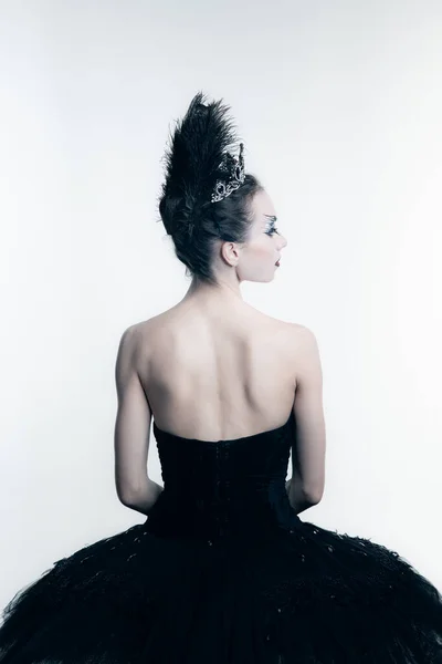 年轻芭蕾舞演员身穿黑色燕尾服的背景图，在白色演播室里摆出孤身一人的舞台服 — 图库照片