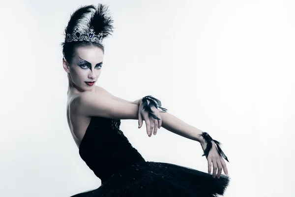Seitenansicht der jungen Ballerina in schwarzem Tutu, Bühnenkleid und hellem Make-up, die isoliert auf weißem Studiohintergrund posiert — Stockfoto