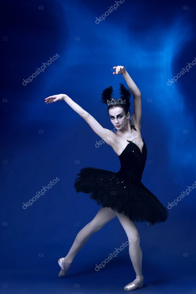 Retrato de una joven increiblemente hermosa mujer bailarina en traje de ballet negro tutu bailando en un estudio azul lleno de luz. Foto de stock vova130555 gmail 518490410