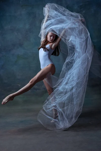 Una joven y flexible bailarina de ballet, bailarina bailando aislada sobre un oscuro fondo de estudio vintage. Arte, movimiento, concepto de acción. — Foto de Stock