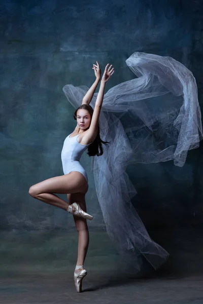 Studio shot van jonge flexibele ballerina dansen geïsoleerd op donkere vintage studio achtergrond. Kunst, beweging, actie concept. — Stockfoto