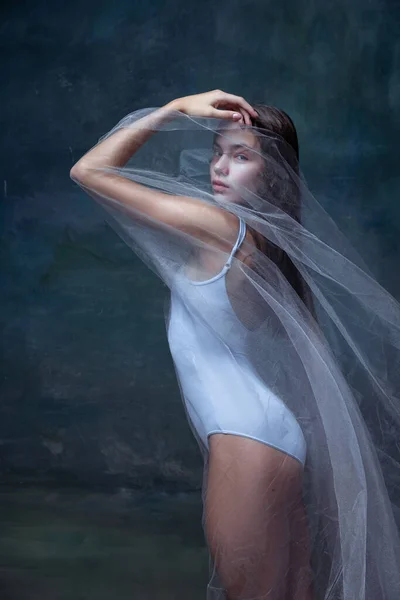 Retrato de menina bonita jovem, bailarina posando com pano transparente branco isolado no fundo do estúdio vintage escuro. — Fotografia de Stock