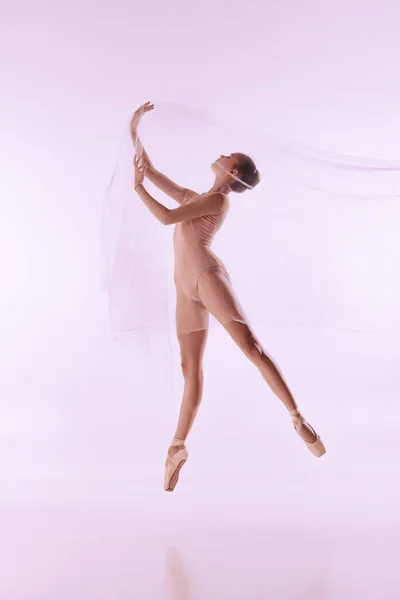 Молодая и изящная балетная танцовщица, балерина танцует изолированно на светлом фоне студии. Искусство, движение, действие, гибкость, концепция вдохновения. — стоковое фото