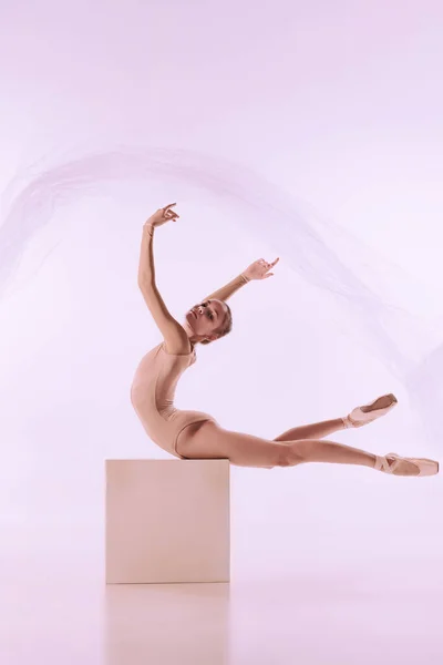 Porträtt av ung flicka, graciös ballerina poserar isolerad på ljus studio bakgrund. Konst, rörelse, handling, flexibilitet, inspirationskoncept. — Stockfoto