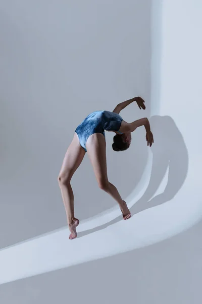 Jonge en sierlijke balletdanseres, ballerina dansen geïsoleerd op een lichte studio achtergrond. Kunst, beweging, actie, flexibiliteit, inspiratie. — Stockfoto