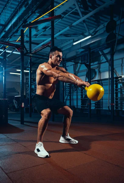 Een gespierde atleet, bodybuilder workouts alleen in sportschool, binnen. Begrip sport, activiteit, gezonde levensstijl — Stockfoto