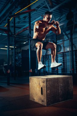 Sportif erkek portresi, spor salonunda vücut geliştirme egzersizleri, kapalı alanda. Spor anlayışı, aktivite, sağlıklı yaşam tarzı