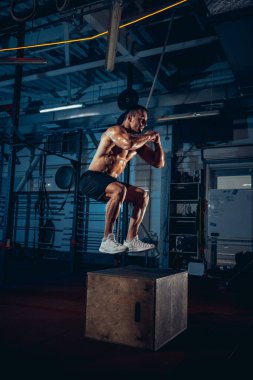 Sportif erkek portresi, spor salonunda vücut geliştirme egzersizleri, kapalı alanda. Spor anlayışı, aktivite, sağlıklı yaşam tarzı