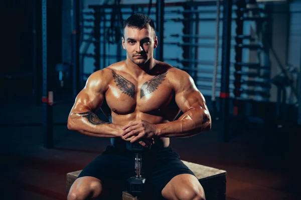 Giovanotto, bodybuilder in posa in palestra, al chiuso. Concetto di sport, attività, stile di vita sano — Foto Stock