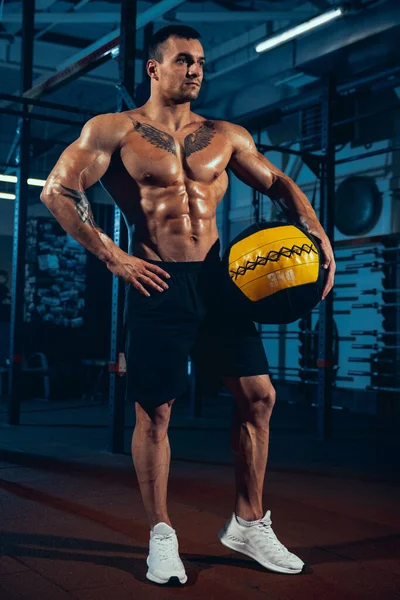 Ritratto di bell'uomo sportivo, bodybuilder in posa in palestra, indoor. Concetto di sport, attività, stile di vita sano — Foto Stock
