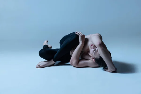 Портрет молодого человека, гибкий мужской балетный танцор, танцующий изолированно на фоне старой военно-морской студии. Искусство, движение, вдохновение. — стоковое фото