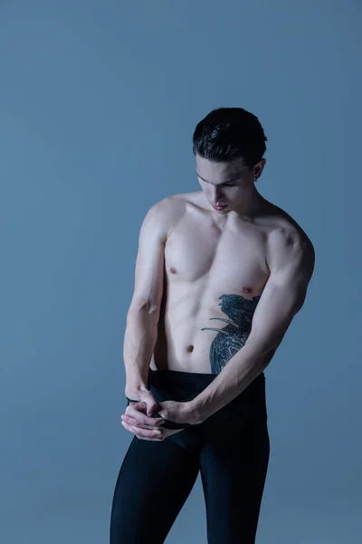 Close-up young muscled man, male ballet dancer posing isolated on old navy studio background. Art, motion, inspiration concept. — Stock Photo, Image