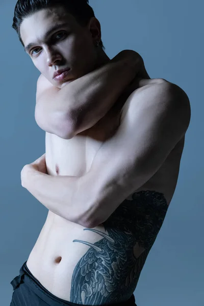Gros plan jeune homme musclé, danseur de ballet masculin posant isolé sur un vieux fond de studio de la marine. Art, mouvement, concept d'inspiration. — Photo
