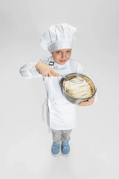 Retrato de niño feliz en cocinero blanco, chaqueta de chef y sombrero de pie aislado en el fondo del estudio blanco. — Foto de Stock