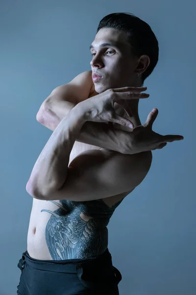 Половинный портрет молодого человека, гибкий мужской танец созерцателя, танцующий изолированно на фоне старой военно-морской студии. Искусство, движение, вдохновение. — стоковое фото