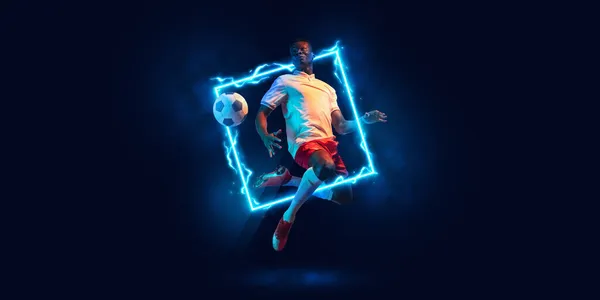 アートコラージュ。若い男,運動中のプロサッカー選手とネオン幾何学的な図と暗い背景に隔離されたボールと行動 — ストック写真