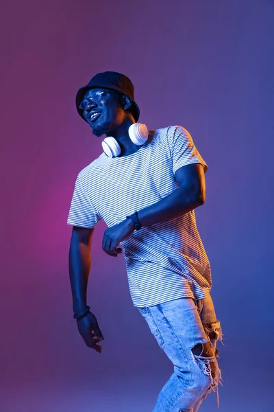 Africain mans portrait isolé sur dégradé pourpre rose fond studio de couleur dans filtre néon avec copyspace pour annonce. Saut en hauteur — Photo