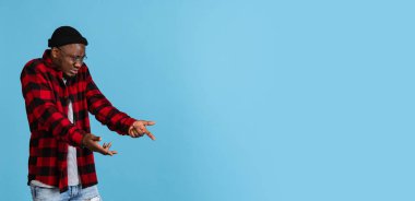 Donanma stüdyosunun arka planında izole edilmiş günlük kıyafetler giyen şık Afrikalı genç bir adamla el ilanı. Duygular, yüz ifadesi kavramı.