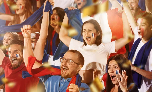 Francouzi vzrušený fotbal, fotbaloví fanoušci jásají nad svým týmem červenými šátky na stáncích na stadionu. Pojetí sportu, emocí, týmové akce, soutěže. — Stock fotografie