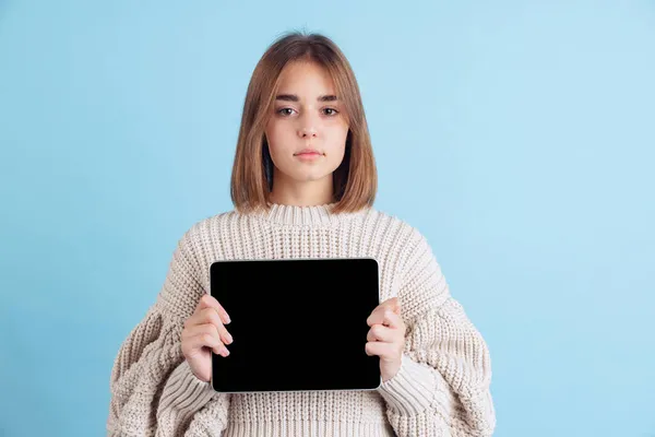 Portrét mladé dívky, dospívající nebo student v ležérní oblečení pomocí tabletu, gadget izolované na modrém pozadí studia. — Stock fotografie