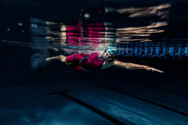 Disparos submarinos. Una nadadora entrenando en la piscina, adentro. Vista submarina de los movimientos de natación detalles. — Foto de Stock