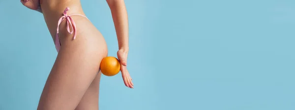 Gros plan sur le corps, les jambes et les hanches des femmes isolées sur fond bleu studio. Beauté naturelle, concept de traitement anti-cellulite. — Photo