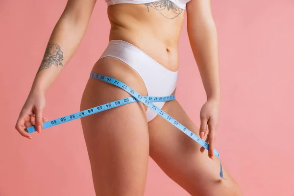 クローズアップスリム女性体でよく保持肌でホワイト綿パンティー使用センチメートル絶縁以上ピンクスタジオ背景. — ストック写真