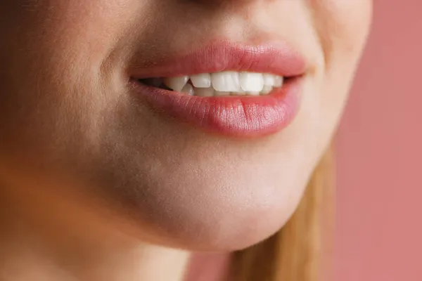 Κοντινό γυναικείο στόμα και μύτη απομονωμένα σε ροζ φόντο στούντιο. Έννοια φυσικής ομορφιάς. Έννοια υγείας οδόντων — Φωτογραφία Αρχείου