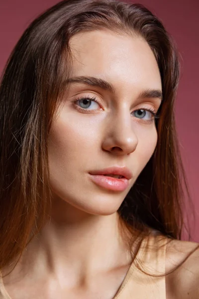 Close-up portret van jong mooi meisje zonder make-up geïsoleerd over donkerroze studio achtergrond. Natuurlijke schoonheid concept. — Stockfoto