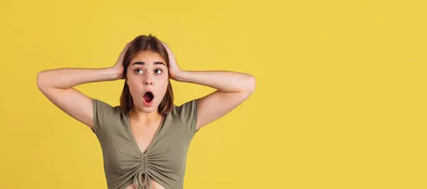 Flyer mit schockiertem jungen Mädchen, Studentin steht mit offenem Mund und schreit isoliert auf gelbem Studiohintergrund. — Stockfoto