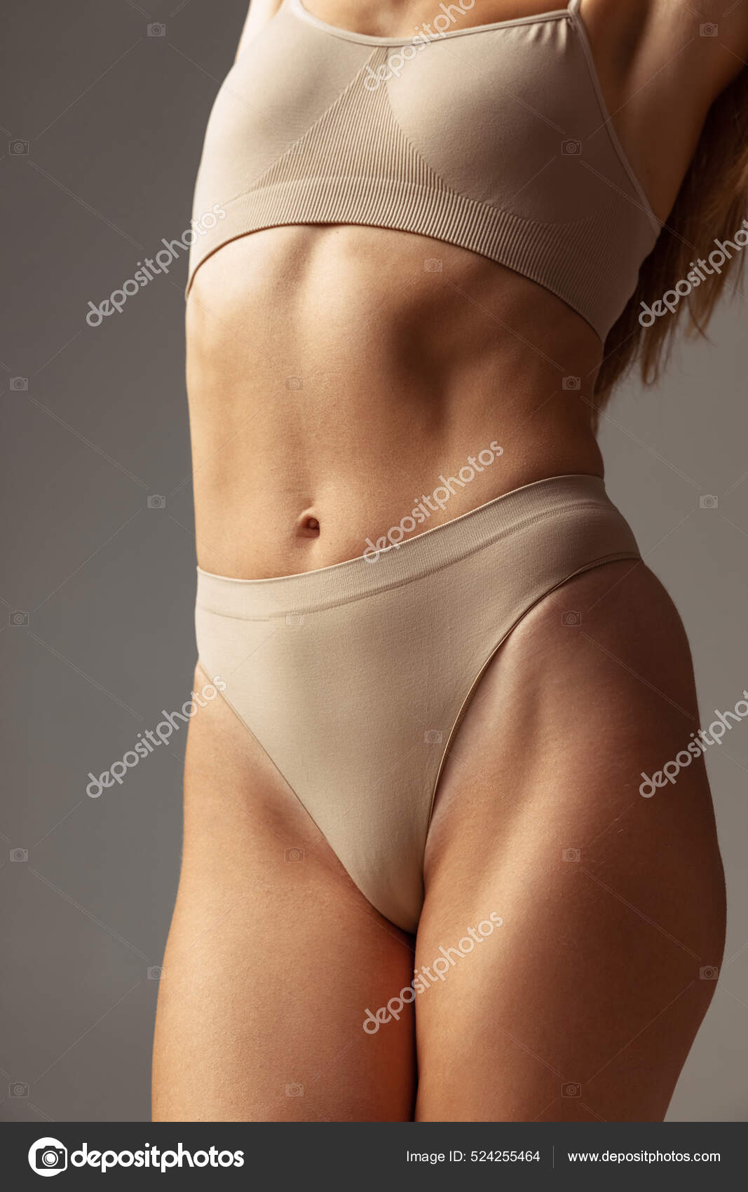 Beautiful Woman Body In Shape. Healthy Girl With Fit Slim Body, Soft Skin.  Flawless woman in on grey background. Photo of girl with slim toned body.  Beauty and body care concept Stock