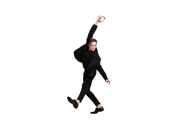 Joven con traje de negocios negro bailando aislado sobre fondo blanco. Arte, movimiento, acción, flexibilidad, concepto de inspiración. — Foto de Stock