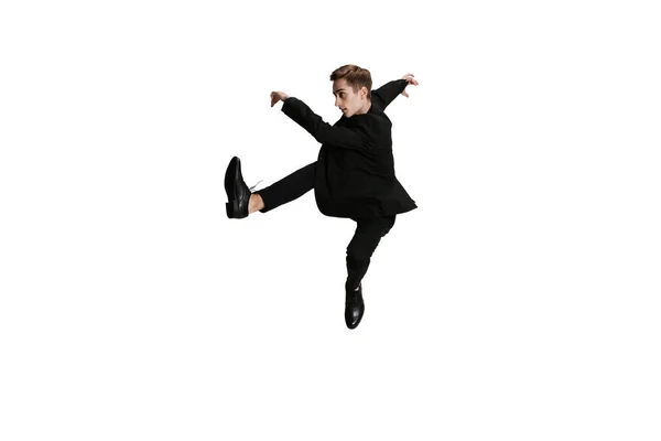 Mladý muž v černém obleku tančí izolovaně na bílém pozadí. Umění, pohyb, akce, flexibilita, inspirace. — Stock fotografie