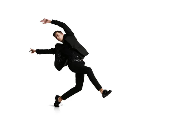 Un joven con traje negro se mueve aislado sobre fondo blanco. Arte, movimiento, acción, flexibilidad, concepto de inspiración. — Foto de Stock